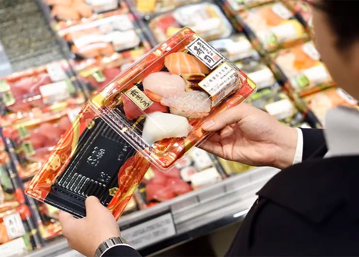 お寿司のトレーを確認する社員