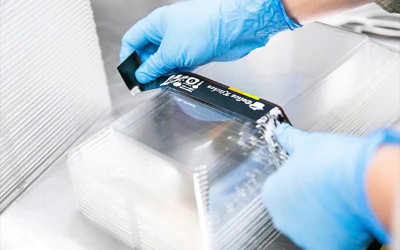 パックに紙の帯をつける店員