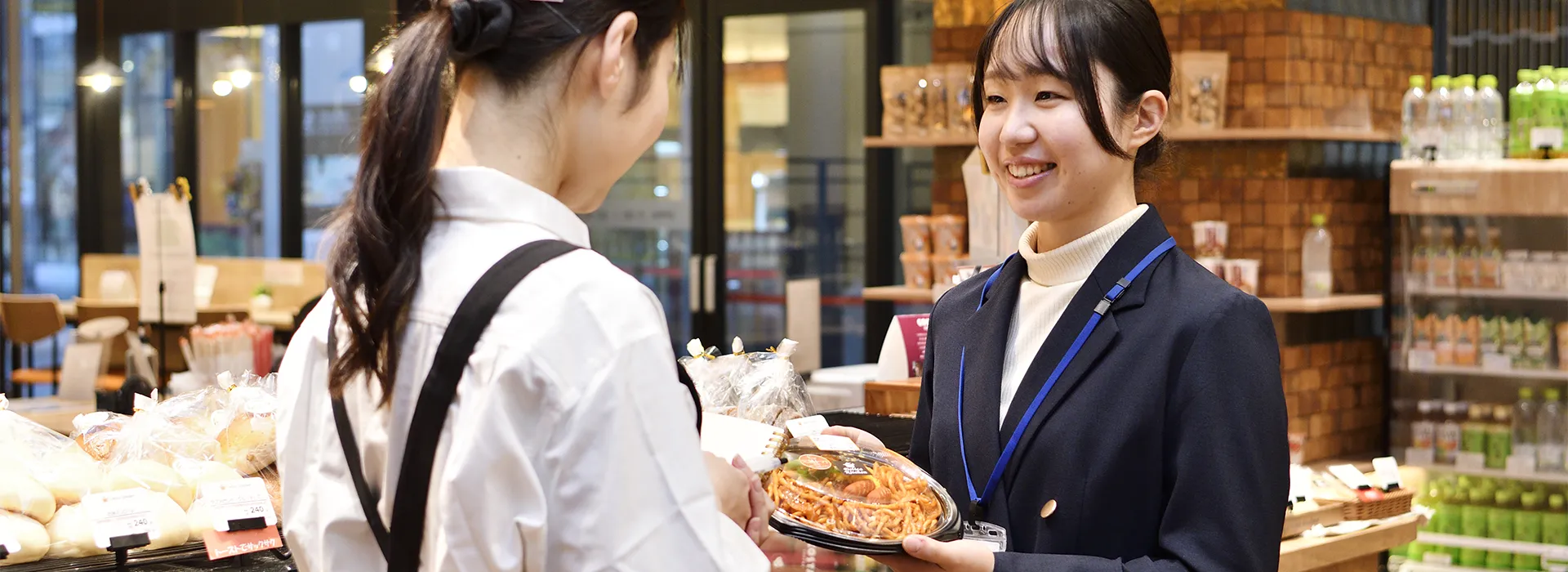 惣菜専門店でトレーの打ち合わせをする社員